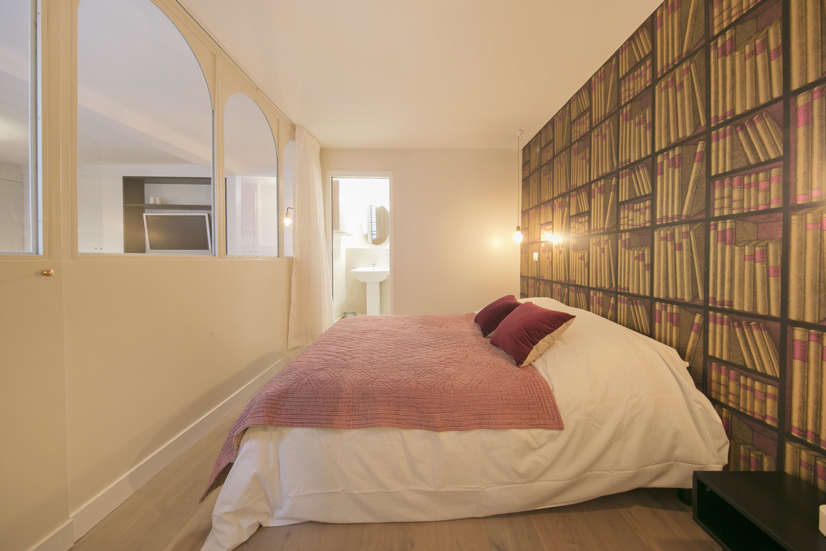 Deze slaapkamer is gedecoreerd met mooie boekenkast behang!