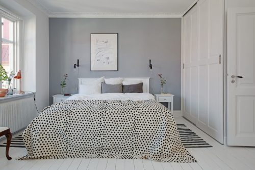 Een grijze muur in een witte slaapkamer