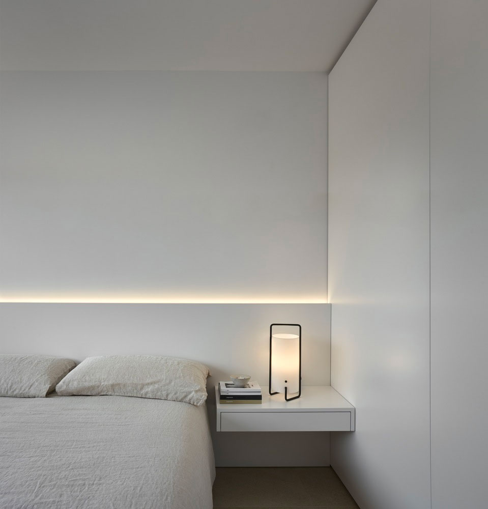 Balzar Arquitectos + Julia Alcocer kozen voor een led-strip achter het hoofdbord in deze strakke moderne slaapkamer. | Fotografie: Mariela Apollonio, Clemente Vergara