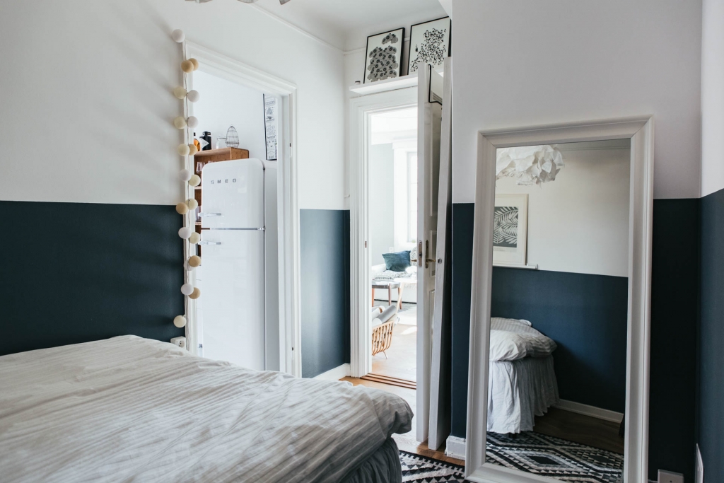 Mooie minimalistische slaapkamer met geverfde blauw lambrisering Mooie minimalistische slaapkamer met geverfde blauw lambrisering