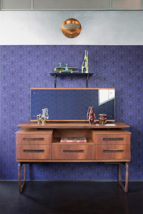 Slaapkamer met paarse muren van een voormalige wapenfabriek Slaapkamer met paarse muren van een voormalige wapenfabriek