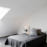 Zolder slaapkamer met zwarte vloer en witte muren